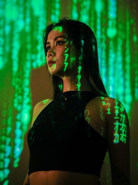 Portrait of a woman with digital matrix-style projections on her face and body